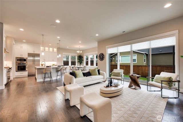 living area with recessed lighting, visible vents, and dark wood finished floors