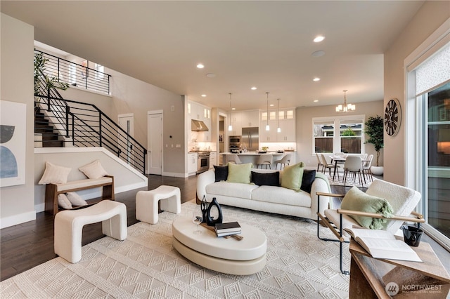 living area featuring baseboards, a chandelier, stairs, recessed lighting, and light wood-style floors