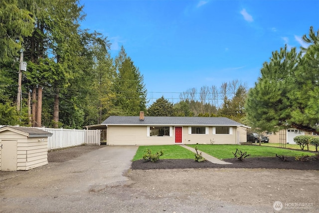 single story home with fence, a front yard, a storage shed, an outdoor structure, and driveway