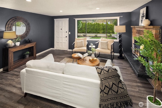 living area with recessed lighting, wood finished floors, baseboards, and a textured ceiling