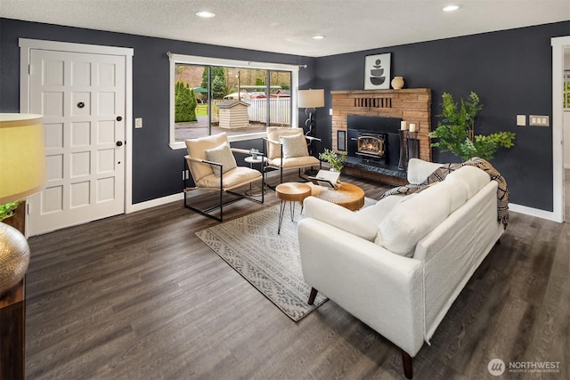 living room featuring baseboards, recessed lighting, wood finished floors, a glass covered fireplace, and a textured ceiling