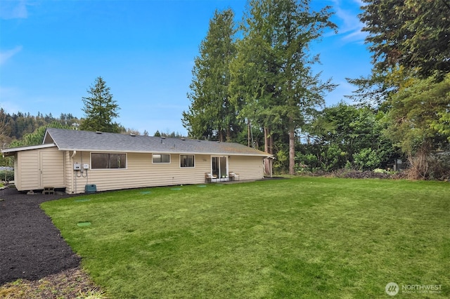 rear view of property with a lawn