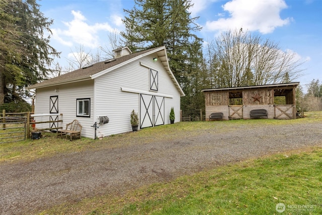 view of home's exterior with an exterior structure, a garage, an outbuilding, and a barn