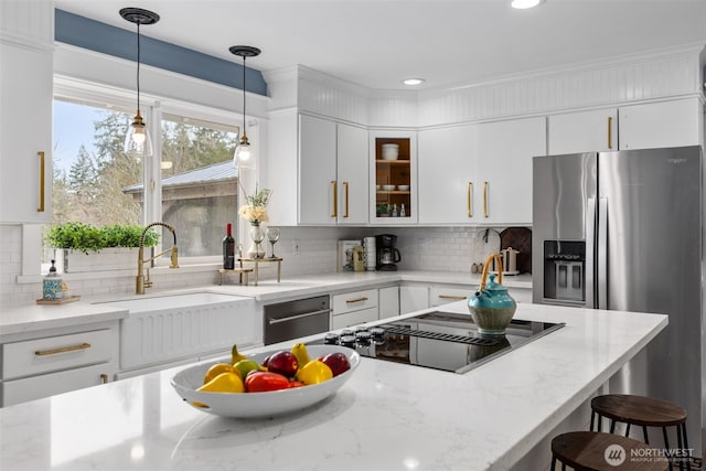 kitchen with backsplash, pendant lighting, a kitchen breakfast bar, white cabinets, and a sink