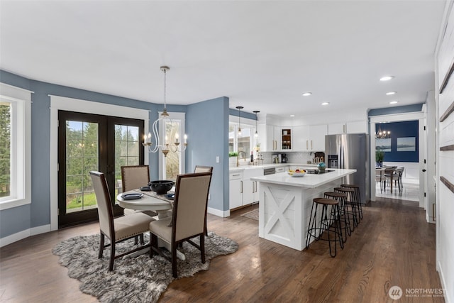 dining space featuring recessed lighting, baseboards, a notable chandelier, and dark wood-style flooring