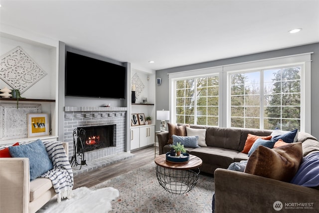 living room with recessed lighting, a fireplace, and wood finished floors