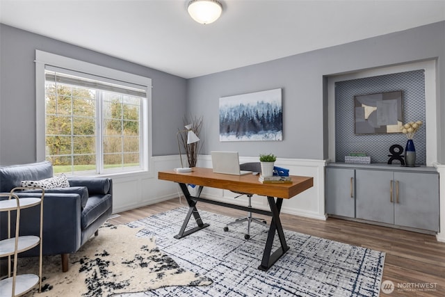 office space featuring wood finished floors and wainscoting