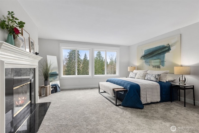 bedroom featuring baseboards, carpet, and a tile fireplace