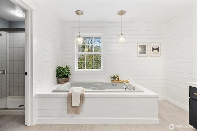 bathroom with a stall shower, vanity, and a garden tub