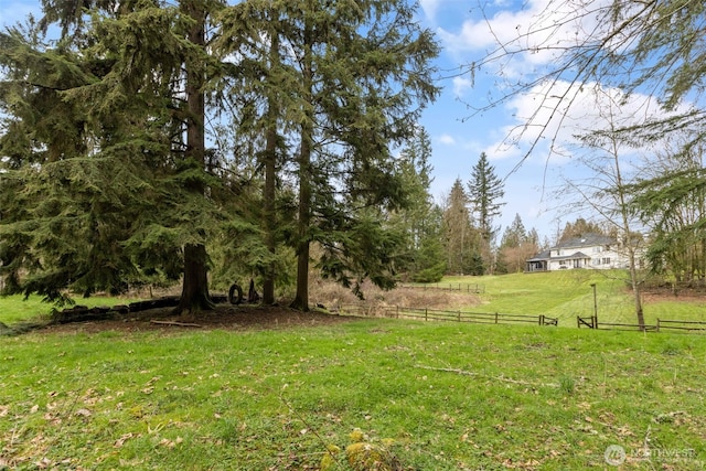 view of yard featuring a rural view and fence