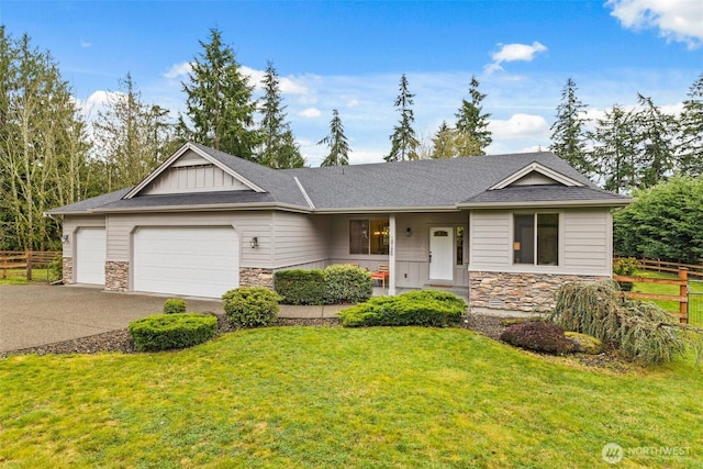 view of front of property with stone siding, concrete driveway, a front lawn, and fence