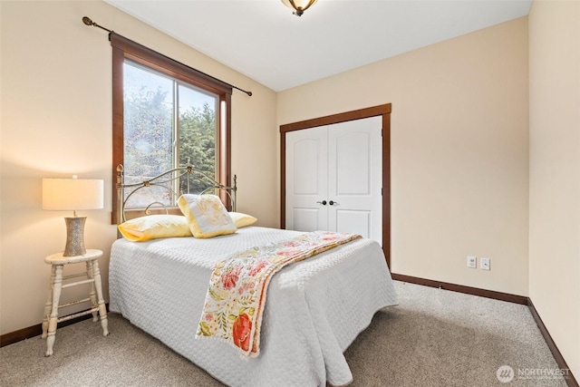 carpeted bedroom with a closet and baseboards