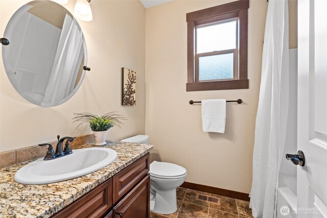 full bathroom with visible vents, toilet, a shower with shower curtain, baseboards, and vanity