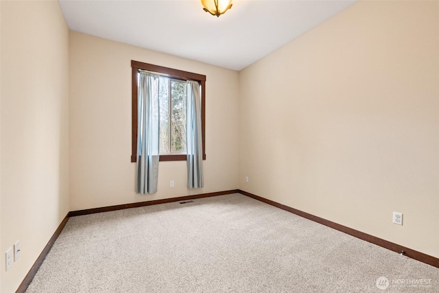 carpeted empty room featuring visible vents and baseboards