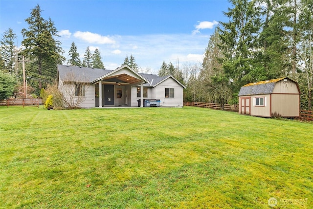 view of front facade with an outbuilding, a storage shed, a front yard, and fence