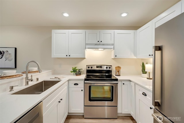 kitchen featuring a sink, white cabinets, under cabinet range hood, and stainless steel appliances