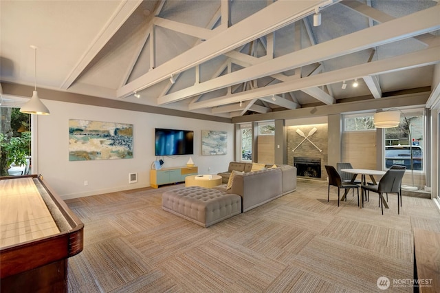 carpeted living area with beam ceiling, a fireplace, high vaulted ceiling, and baseboards