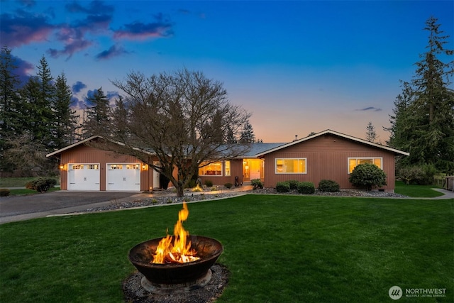 single story home featuring aphalt driveway, an attached garage, and a front yard