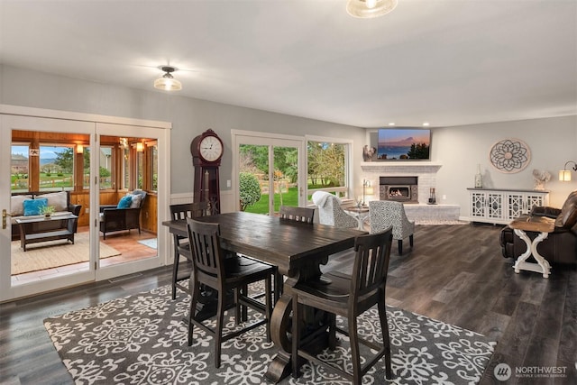 dining space featuring a brick fireplace, french doors, dark wood-style flooring, and a wealth of natural light