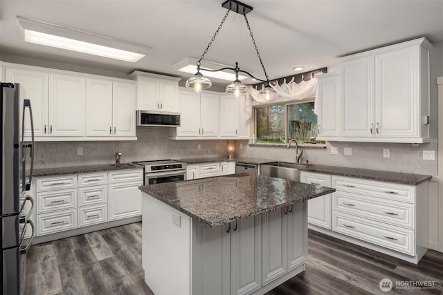 kitchen with a sink, stainless steel appliances, white cabinets, and dark wood-style flooring