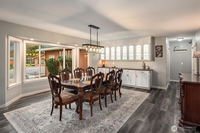 dining space with visible vents, baseboards, and dark wood-style flooring