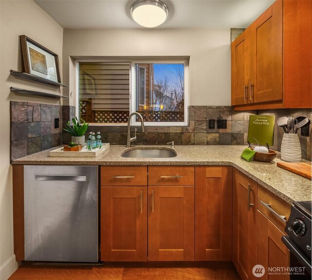 kitchen featuring a sink, decorative backsplash, light stone countertops, and stainless steel dishwasher