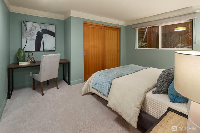 carpeted bedroom featuring a closet and baseboards