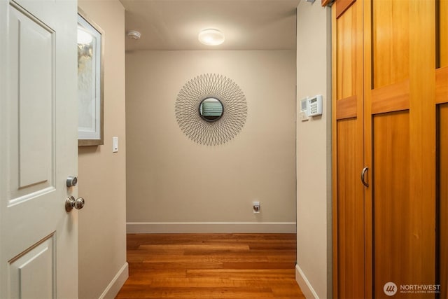 hallway featuring baseboards and wood finished floors