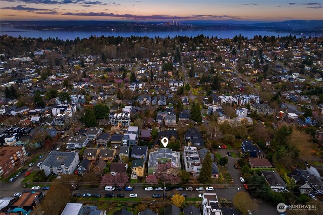 aerial view at dusk featuring a water view