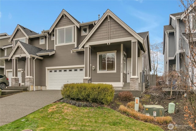 craftsman inspired home with driveway, an attached garage, and a shingled roof