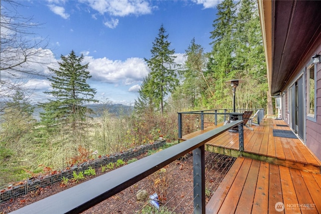 wooden terrace featuring a view of trees