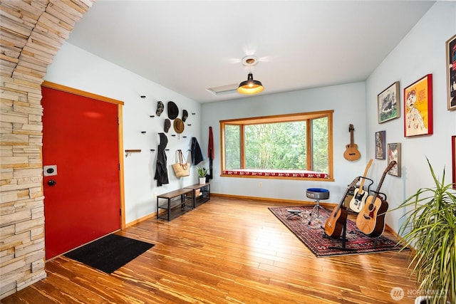 foyer featuring baseboards and wood finished floors