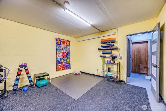 exercise room featuring concrete block wall