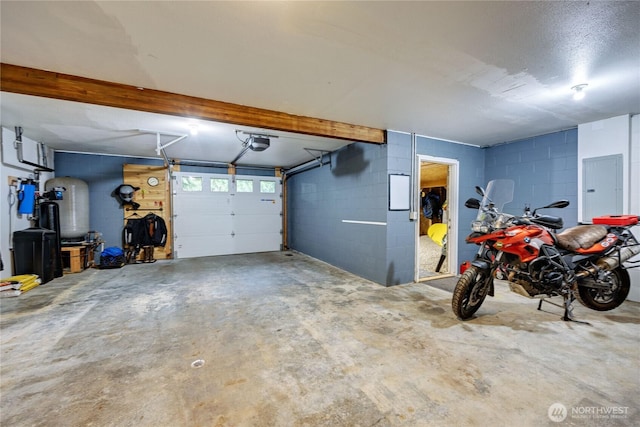 garage featuring concrete block wall, electric panel, and a garage door opener