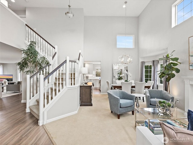 living room with a notable chandelier, stairs, baseboards, and wood finished floors