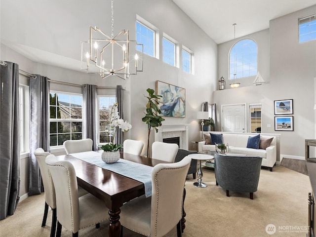 dining area with baseboards, a notable chandelier, a healthy amount of sunlight, and a fireplace