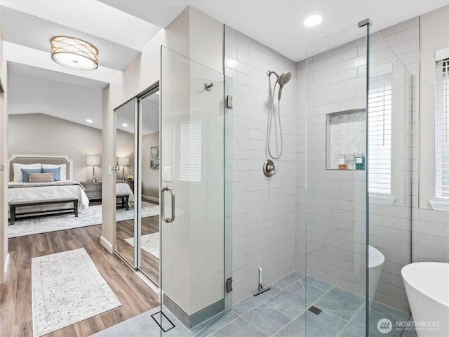 ensuite bathroom with a freestanding tub, wood finished floors, recessed lighting, connected bathroom, and a shower stall