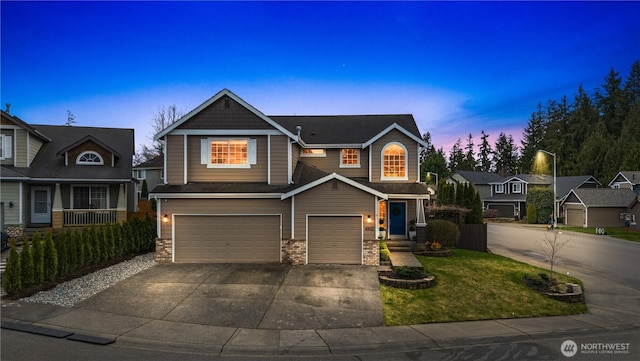 craftsman inspired home with stone siding, driveway, and an attached garage