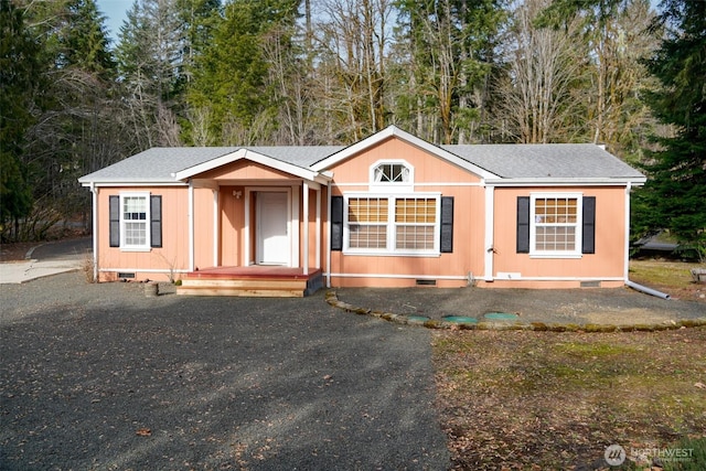 view of front of house with crawl space and a shingled roof