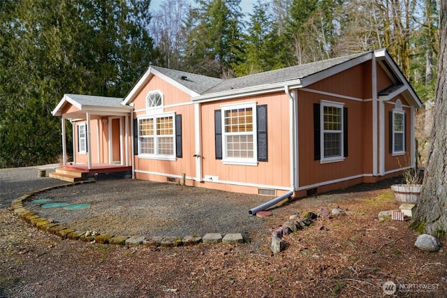 view of front of house featuring a shingled roof and crawl space