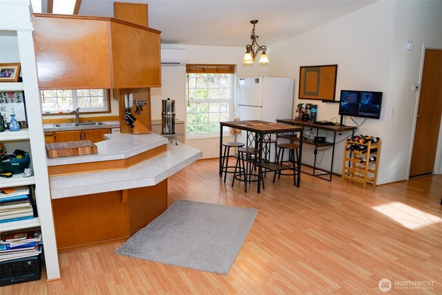 610 N Duckabush Dr N, Hoodsport, WA 98548 - kitchen with an inviting chandelier, freestanding refrigerator, a sink, a kitchen breakfast bar, and light wood-type flooring