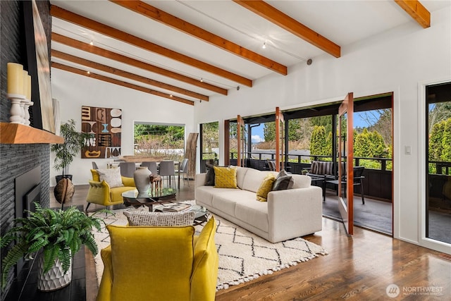 living room with beam ceiling, a healthy amount of sunlight, and a fireplace