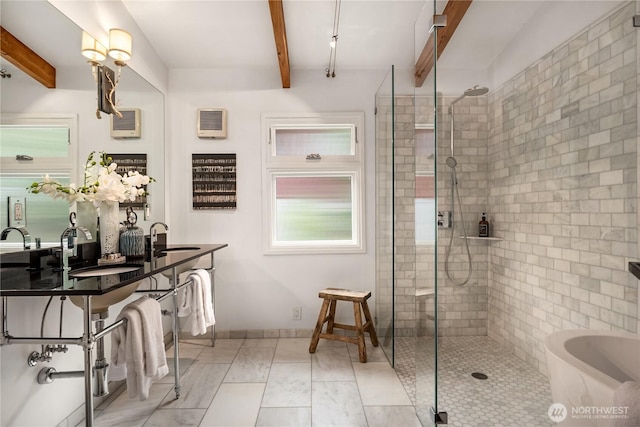 bathroom featuring a sink, beamed ceiling, and a tile shower