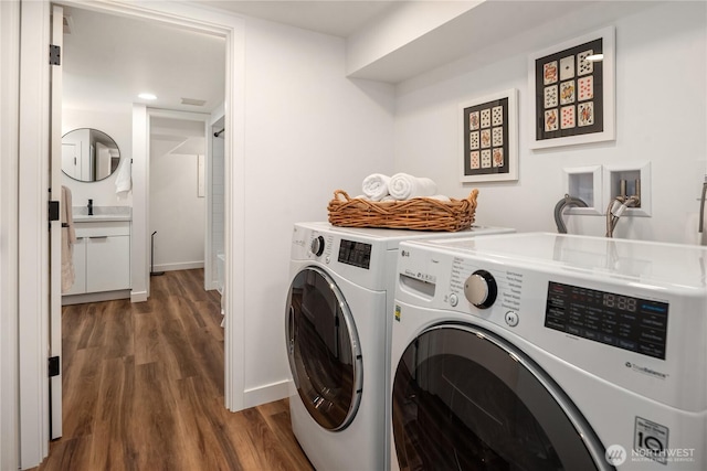 laundry room featuring baseboards, washing machine and dryer, recessed lighting, wood finished floors, and a sink