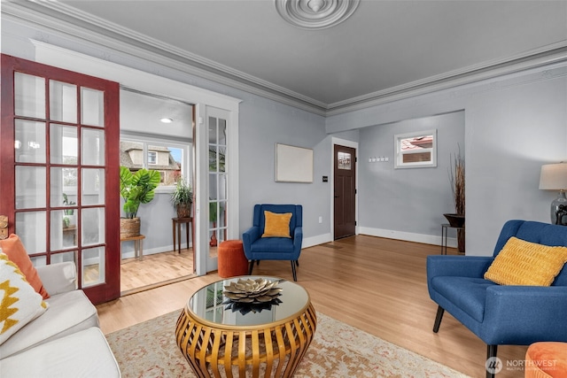 sitting room with crown molding, baseboards, and wood finished floors