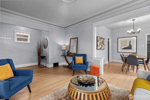 living room with a notable chandelier, baseboards, light wood finished floors, and ornamental molding