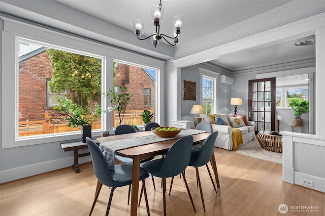 dining space with baseboards, a wall mounted AC, ornamental molding, a notable chandelier, and light wood-type flooring