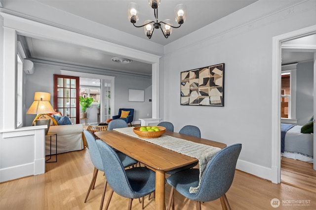 dining space featuring a chandelier, light wood-style flooring, french doors, and baseboards