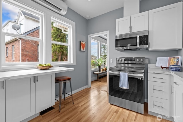 kitchen with light wood finished floors, visible vents, light countertops, appliances with stainless steel finishes, and white cabinetry