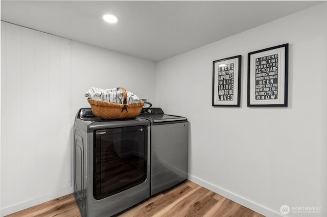 clothes washing area with laundry area, independent washer and dryer, light wood-type flooring, and baseboards